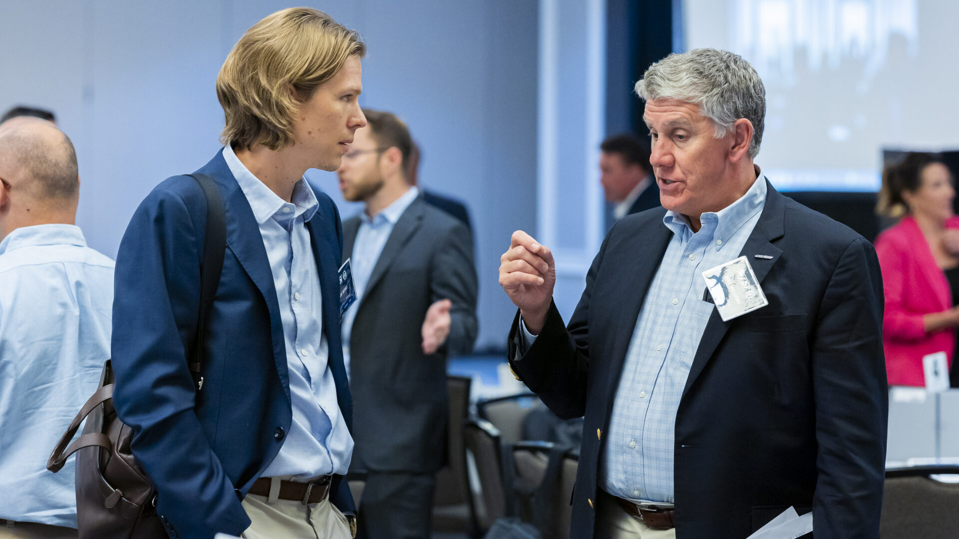 Two individuals shaking hands during outdoor networking or demonstration event.