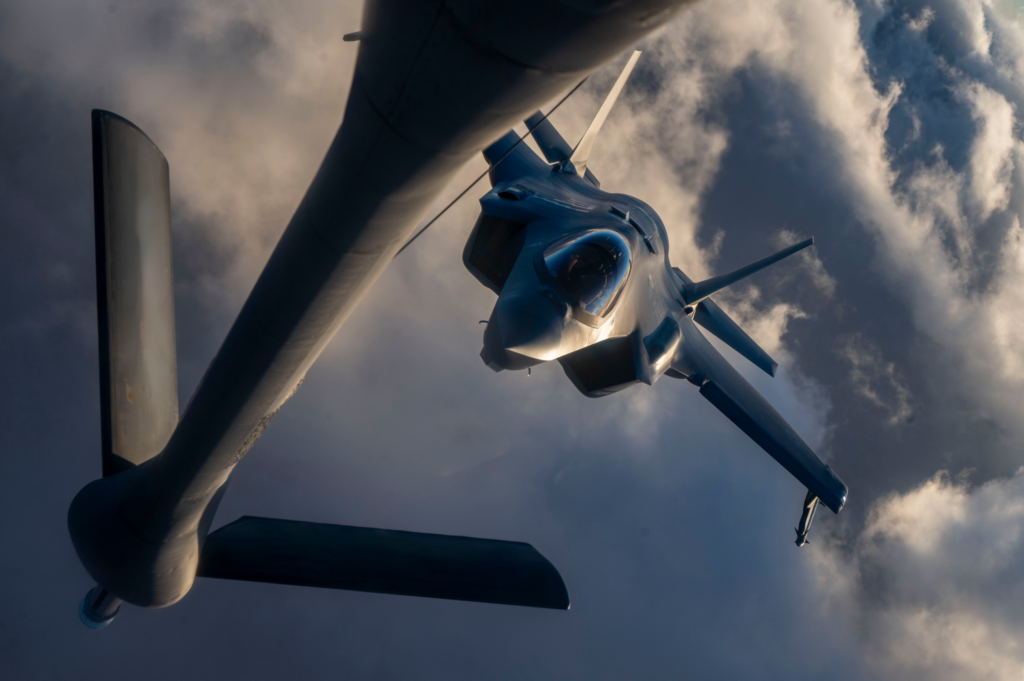 Aircraft viewed in flight from below during aerial operation.