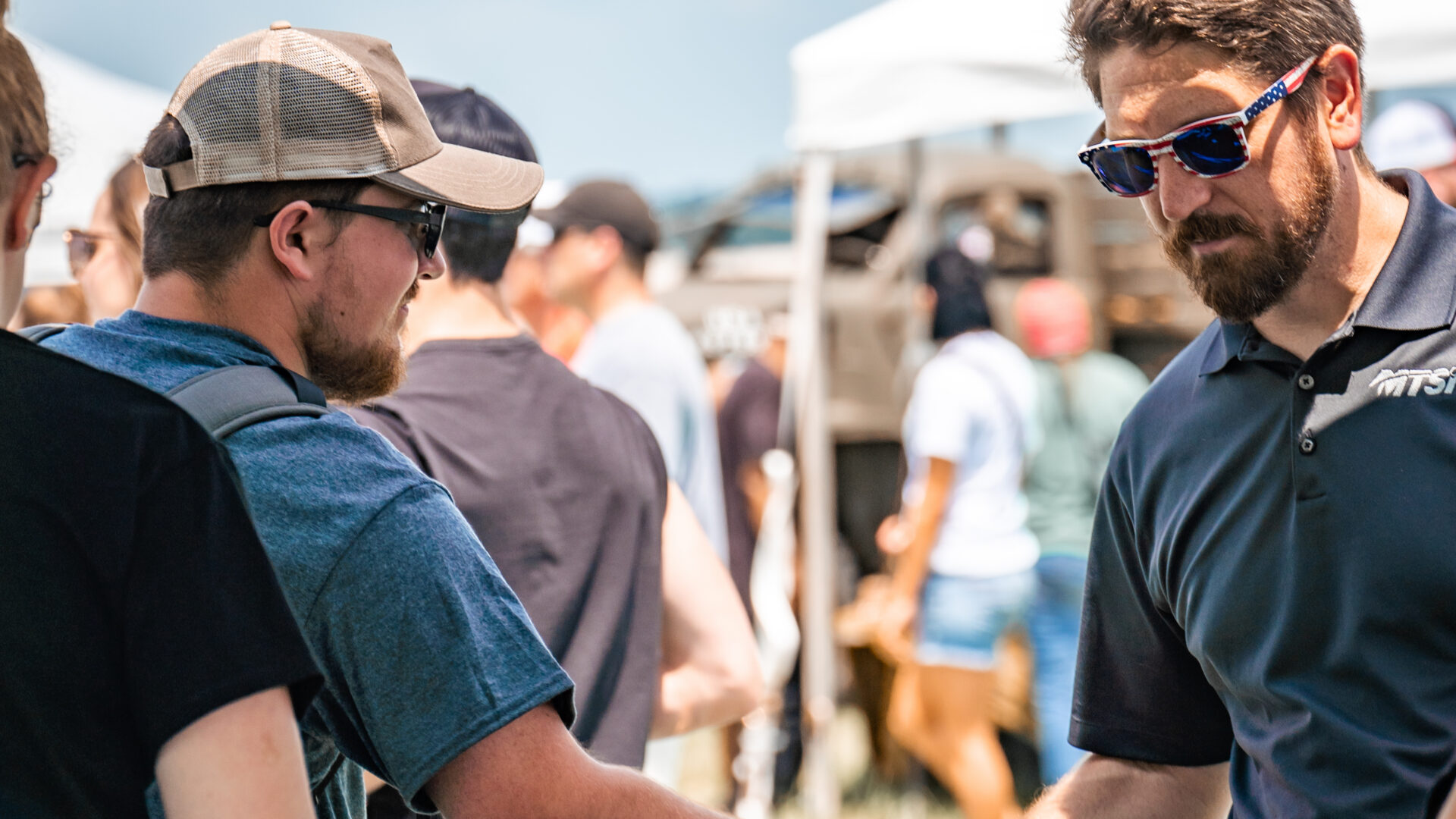 MTSI representative shaking hands with attendee at an outdoor event.