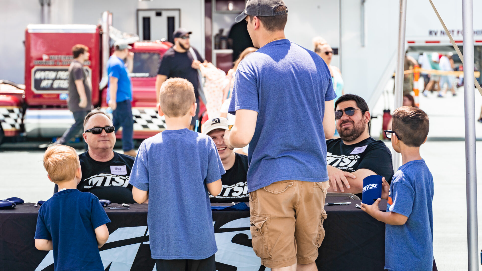 Community members and event staff interacting at outdoor outreach or aviation event booth.