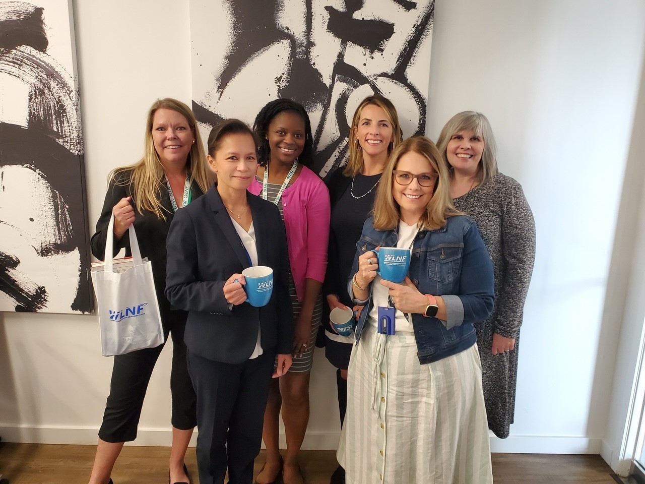 Group of professionals posing together indoors during networking or organizational event.
